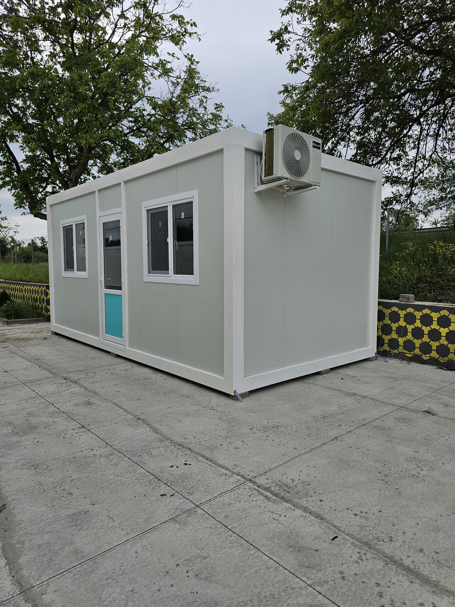 Container modular gri cu unitate de aer condiționat montată exterior